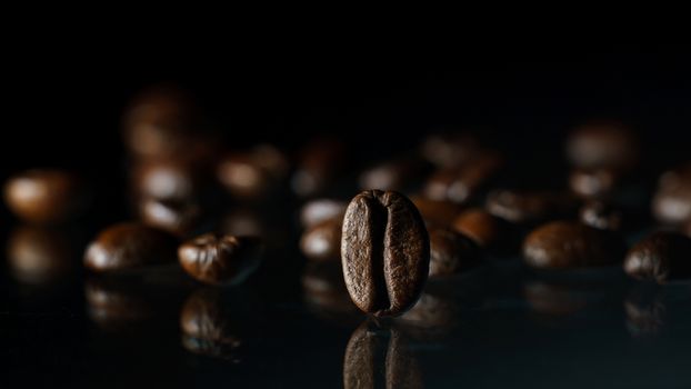 Roasted coffee beans pile on glass reflection background.