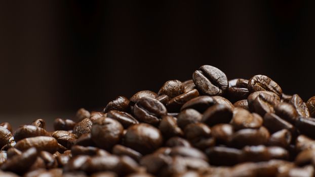 Roasted Coffee Beans texture on dark background, macro.