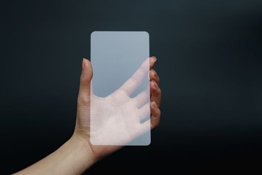 Hand holding and showing transparent smartphone. Business, technology concept.