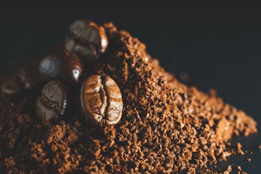 Ground coffee and coffee beans on black background.