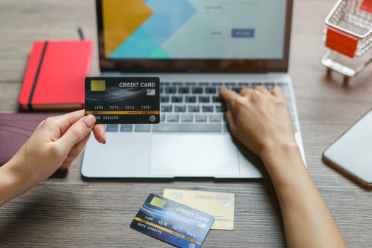 Woman hands holding and using cradit card for shopping online.