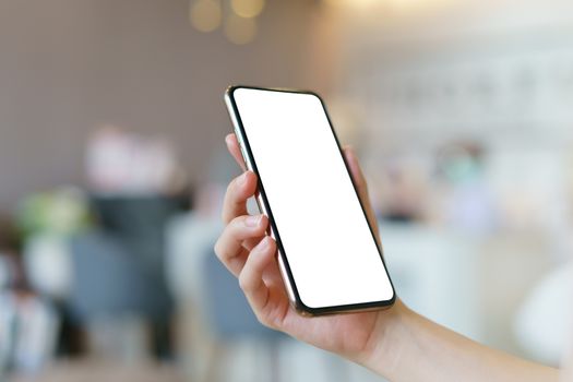 Mockup image of hand holding mobile phone with blank white screen.