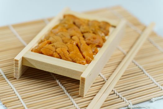 Japanese sea urchin in wooden tray , sushi and sashimi ingredients