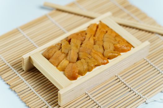 Japanese sea urchin in wooden tray , sushi and sashimi ingredients