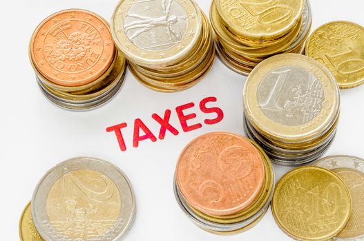 Many Euro coins and red "Taxes"