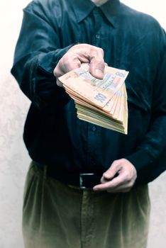 Corrupted businessman, or politician, offering a Hryvnia banknotes bribe, in Ukraine