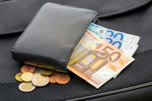 A black leather wallet with Euro banknotes and coins