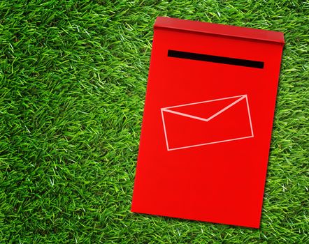 Communication concept, red mail box on green grass background