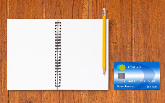 Credit card, notebook and yellow pencil on wood background, online payment, electronic commerce financial concept  