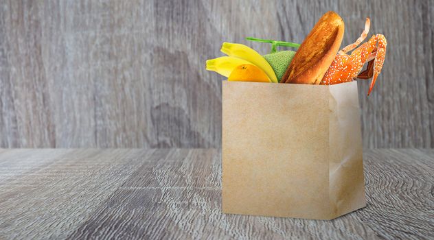 Grocery shopping concept, supermarket retail product in brown paper bag on wood background