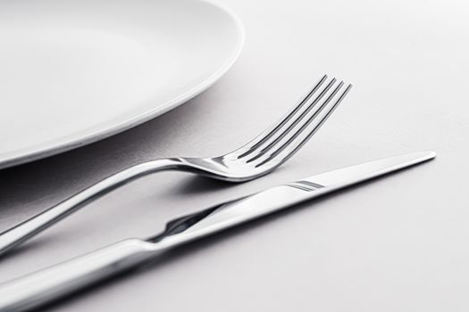 Empty plate and cutlery as mockup set on white background, top tableware for chef table decor and menu branding design