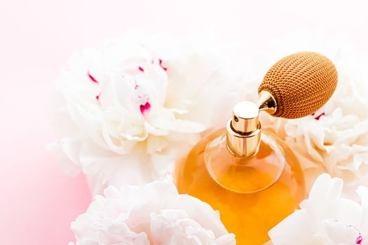 Chic fragrance bottle as citrus perfume product on background of peony flowers, parfum ad and beauty branding design