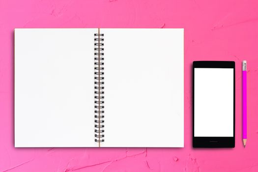 Notebook and mobile phone on pink background, business concept