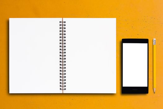 Notebook and mobile phone on yellow background, business concept