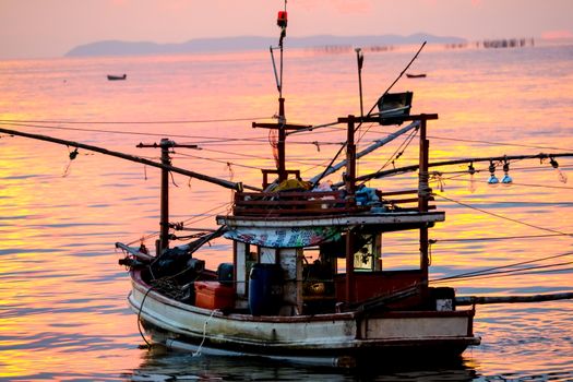 colorful flame cloud sunset fisging boat on sea and sky background