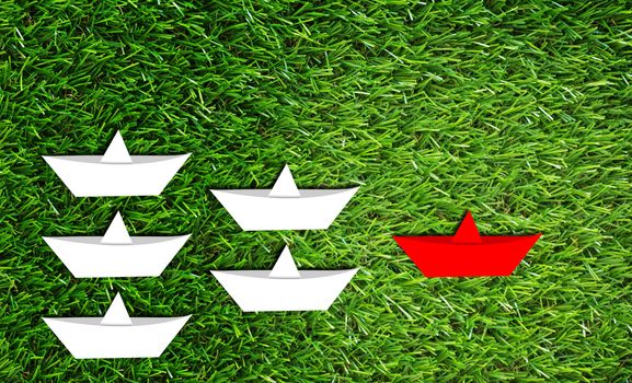 Leadership concept, paper boat on green grass background, business success concept