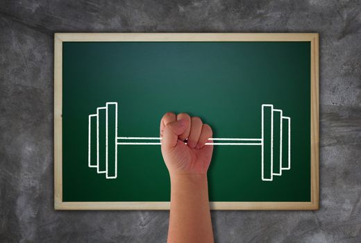 Business success concept, hand and weight lifting target to growth and achievement on blackboard background