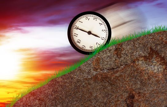 Time concept, clock moving down the hill