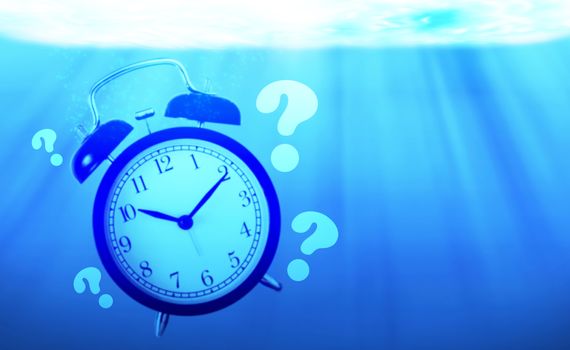 Time management concept, business planning, alarm clock drowning in the sea 