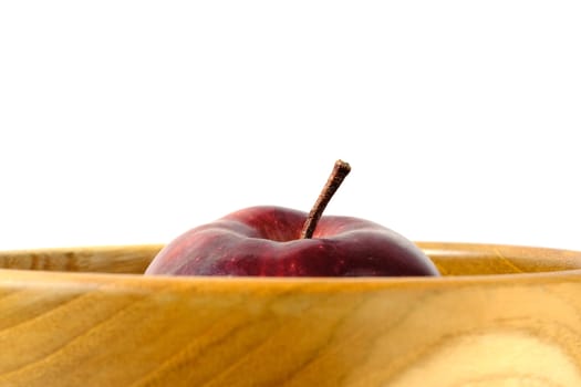 Close up single red Apple above wooden bowl / basket isolated on white background