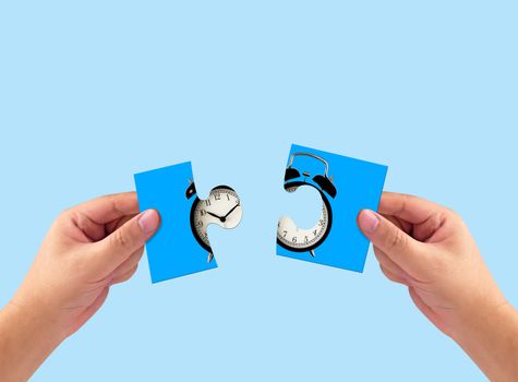 Time management concept, business strategy and planning, retro alarm clock puzzle on hand in blue vintage background
