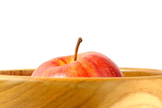 Close up single red Apple above wooden bowl / basket isolated on white background