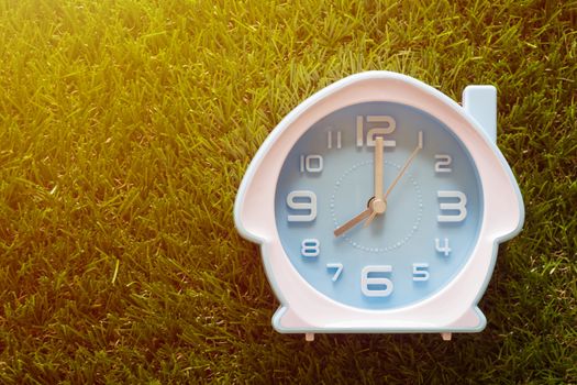 Time management concept, business planning, good morning, alarm clock on green grass background