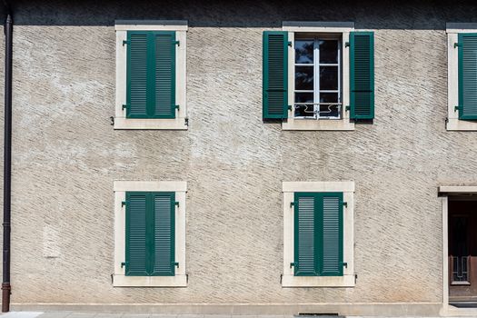 Facade of a stone house with green shutters. Swiss - French border - image