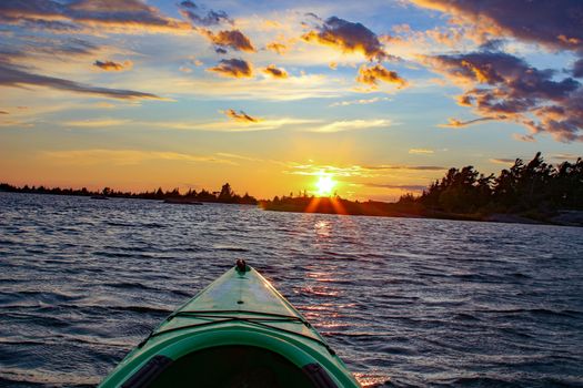 Image of empty red canoe floating, Georgian Bay sunset