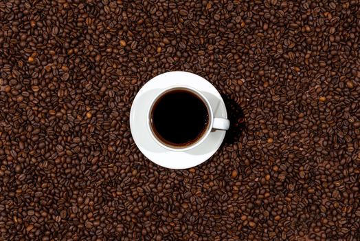 Top view of white coffee mug on the coffee beans background - image
