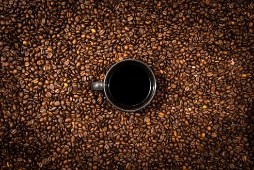 Top view of black coffee mug on the coffee beans background - image