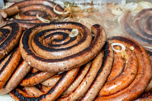 Grilled sausage with onions and sauce, top view
