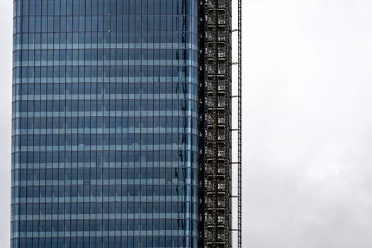 close-up of a modern office building against a gray sky in Manhattan, New York City