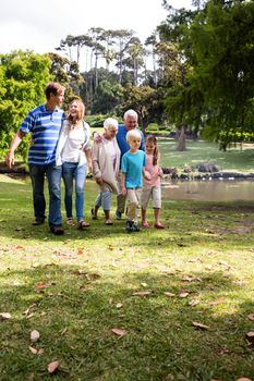 Multi-generation family walking together in the park on a sunny day