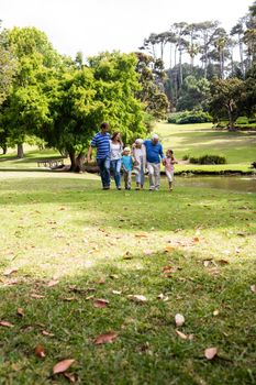 Multi-generation family walking together in the park on a sunny day