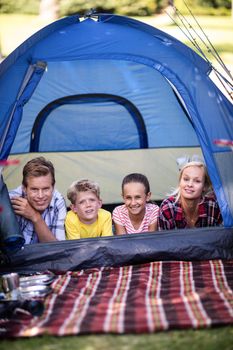Portrait of happy family lying in a tent