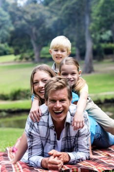 Happy family lying in park on a sunny day