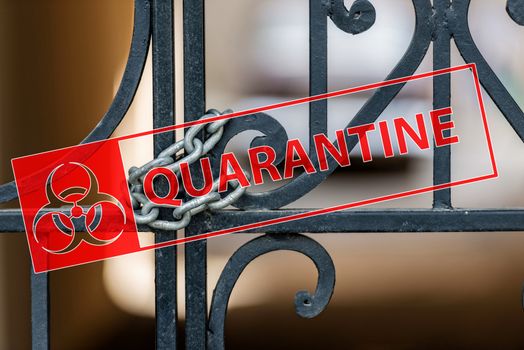 Coronavirus quarantine sign on the background of an ornamental iron gate locked with chain