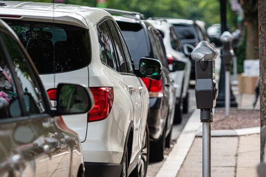 a row of parked cars on the side of the street and a parking payment machine in Princeton, USA