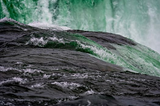 Niagara Falls splash close-up on a sunny day, lowing water background
