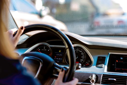 car steering wheel with driver hands on it, close-up of woman hands holding steering wheel