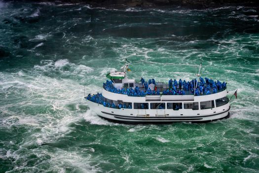 Ship with tourists moves to Niagara falls, Falls boat tour experience is North America oldest attraction, and has drawn millions of visitors since 1846