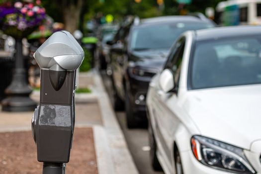 a row of parked cars on the side of the street and a parking payment machine in Princeton, USA