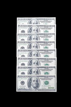 stacked in a row 100 US dollar bills with a portrait of American President Benjamin Franklin on an isolated black background