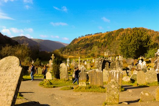 GLENDALOUGH, IRELAND - February 19 2018: The ancient cemetery in monastic site Glendalough. Glendalough Valley, Wicklow Mountains National Park, Ireland. Glendalough is home to one of the most important monastic sites in Ireland. This early Christian monastic settlement was founded by St. Kevin in the 6th century and from this developed the 'Monastic City'.