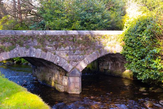 The small brook and arched stone bridge at the ancient Glendalough monastic site in the Wicklow mountains in Ireland.