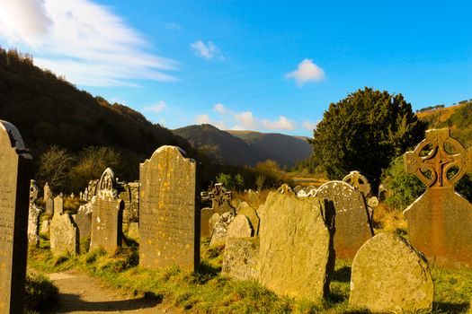 GLENDALOUGH, IRELAND - February 19 2018: The ancient cemetery in monastic site Glendalough. Glendalough Valley, Wicklow Mountains National Park, Ireland. Glendalough is home to one of the most important monastic sites in Ireland. This early Christian monastic settlement was founded by St. Kevin in the 6th century and from this developed the 'Monastic City'.
