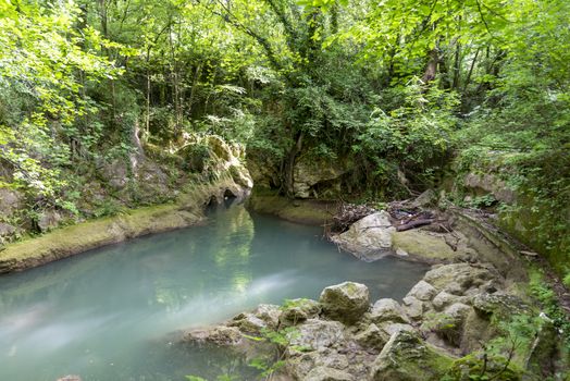 black river that comes from the marmore waterfalls in the middle of nature