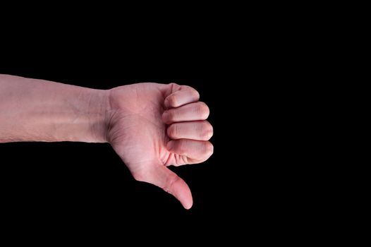 Hand of european man shows thumbs-down sign on isolated black background