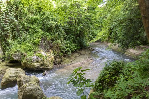 black river that comes from the marmore waterfalls in the middle of nature